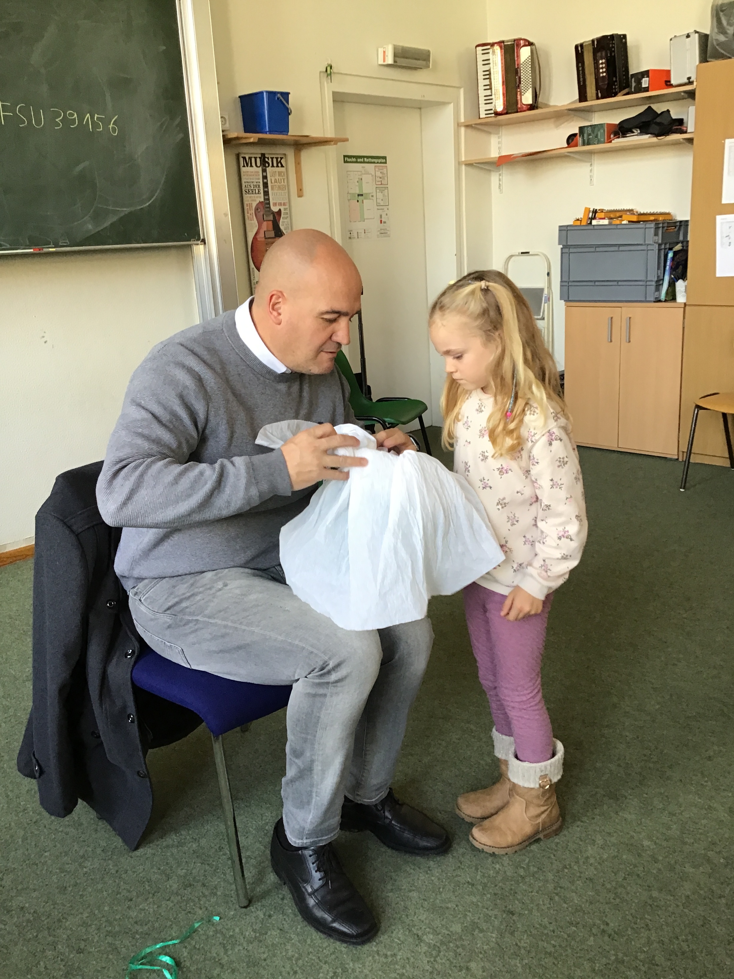 Schülerin wirft Blick in die Schultüte von Herrn Faulhaber.JPG.jpeg