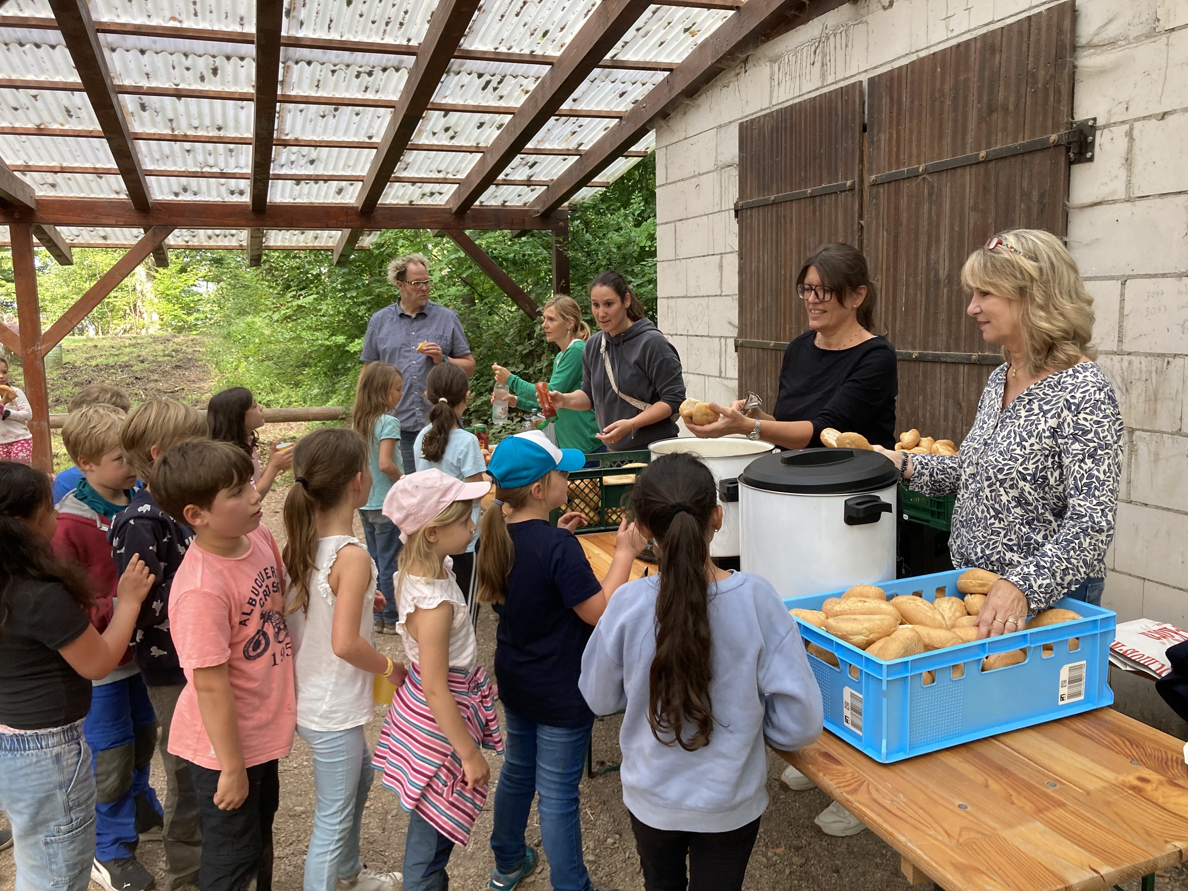 Kinder stehen an der Wurstausgabe an.